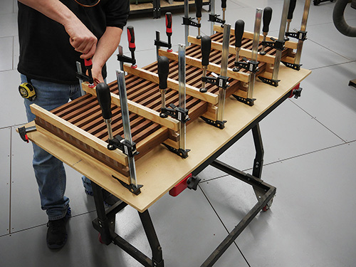 Distributing clamping pressure on coffee table cross laps and slats with clamping cauls