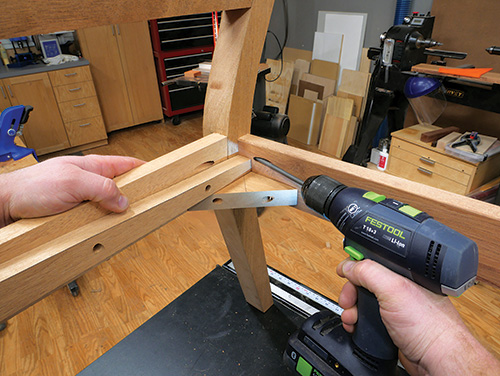 Securing back apron in love seat frame