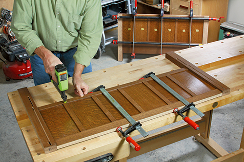 Using nail gun to install storage chest panels