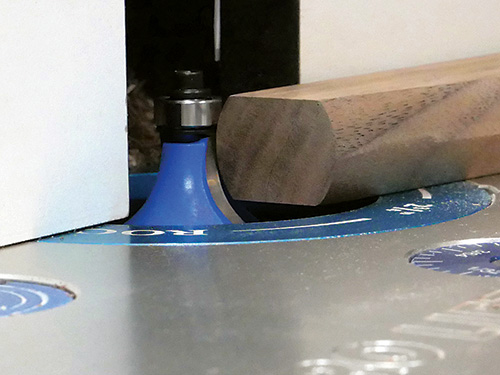 Close-up on router bit making a fingernail profile cut