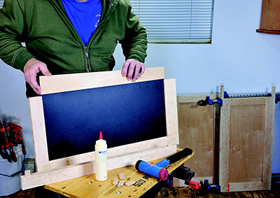 When gluing up the outer doors for the upper cabinet, slide one of the special magnetic chalkboard sheets in atop the plywood panel.