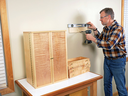 Hanging french cleat bar on wall to hang tool storage cabinet
