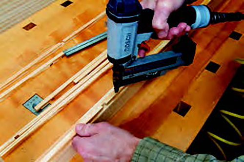 Use a pin nailer to attach the vertical perimeter strips first, then the horizontal strips. There’s no need to glue the strips, and it's unnecessary to fill the pin-nail holes because they're almost invisible.