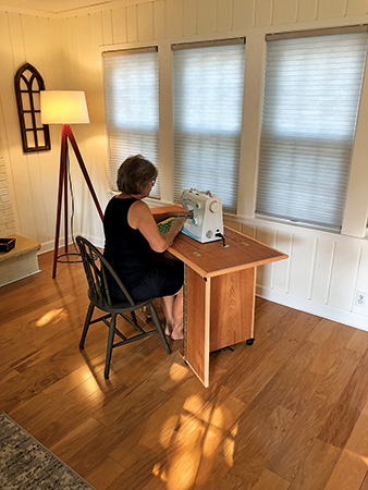 Using sewing machine installed in mobile sewing cabinet