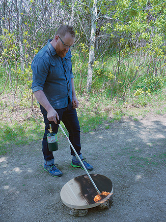 Charring cedar tabletop with flame thrower