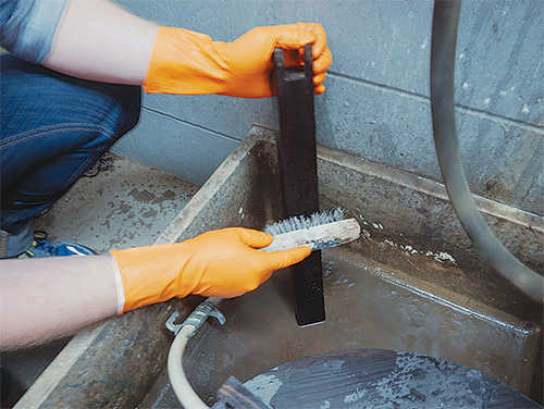 Brushing down patio table legs after charring