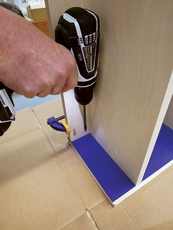 Screwing kickplate onto bookcase panel