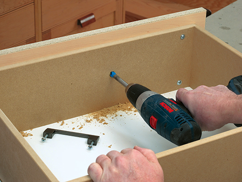 Using small forstner bit to drill installation hole for dresser drawer front