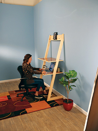 Sitting at completed standing desk using lower shelf