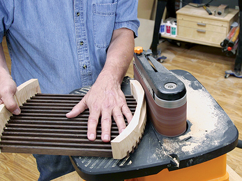 Smoothing out trivet end with belt sander