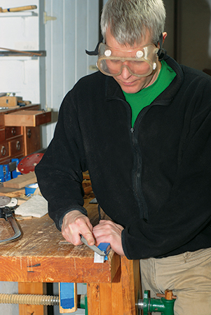 Sawing excess metal off ends of coffee table stretcher