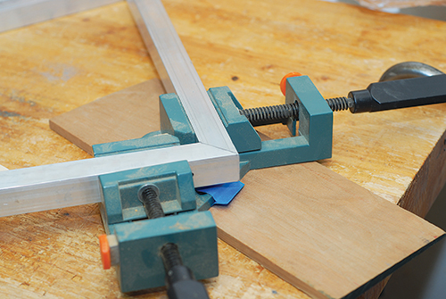 Holding coffee table frame assembly together with corner clamps