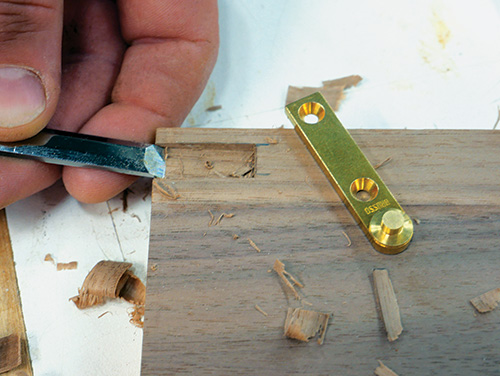 Cleaning hinge mortise groove with chisel