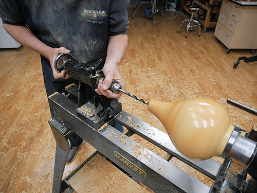 Using lathe to drill wiring hole in turned box elder lamp body