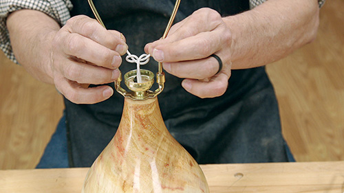 Knotting wire running through turned lamp body