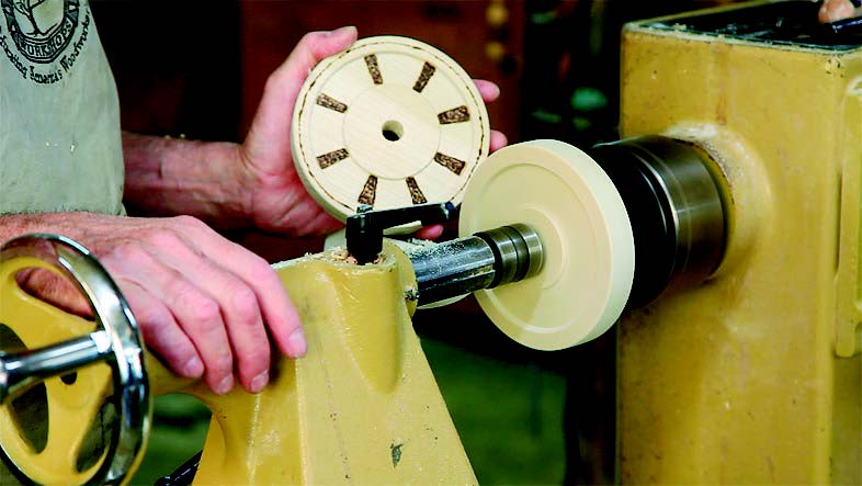 Once your wheel is turned to the layout diameter, you can scrape the face so that it looks like a wheel and tire, or burn decorative wood spokes.