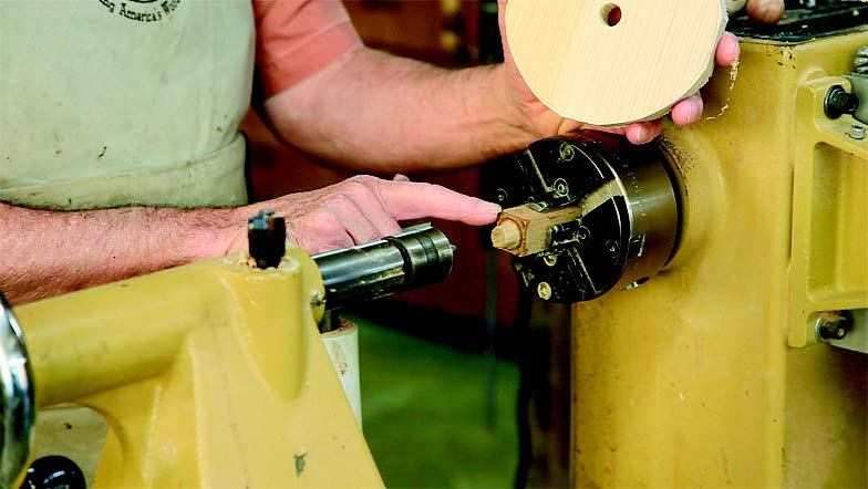 When turning wheels, pin the blank on an improvised chuck: just a billet with a squareshouldered tenon that is a snug fit with the diameter of the bore.