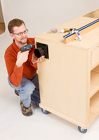 Screwing dust port into side of miter saw stand