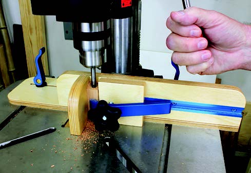 Adjusting clamps to attach drilling fence to drill press