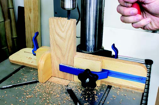 Drilling into workpiece secured in drill press fence