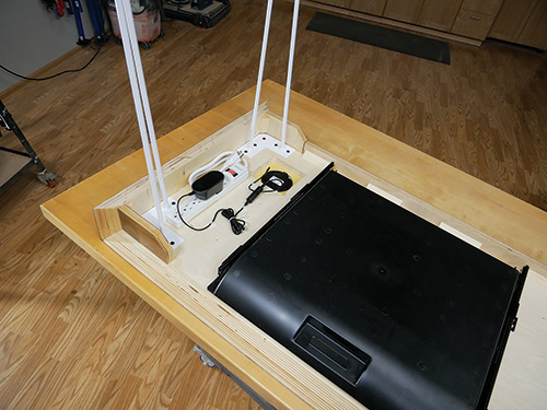 Underside of waterfall desk with power cable and desk tray