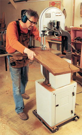 Cutting chair part along cut line with band saw