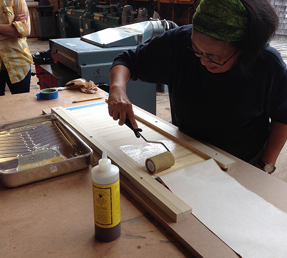 We used Old Brown Glue to adhere the canvas to the tambours. It is flexible, and it acts as traditional hide glue (heat required, but also reversible).