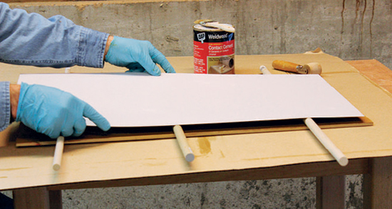 Bond the top laminate to the middle MDF layer with contact cement. Dowel spacers make it easier to position the laminate accurately.